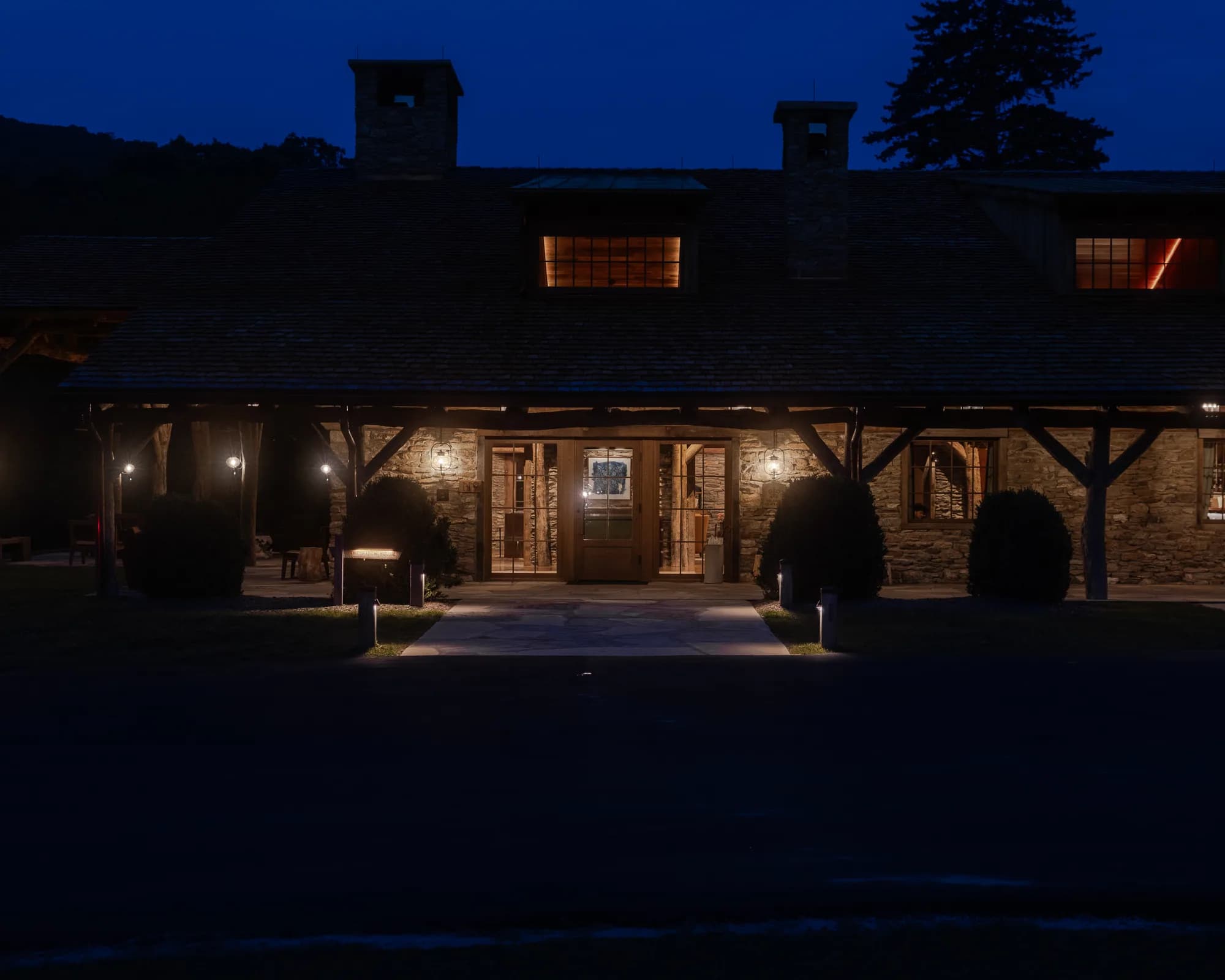 Cataloochee Ranch in North Carolina with its stone and timber porch illuminated at night