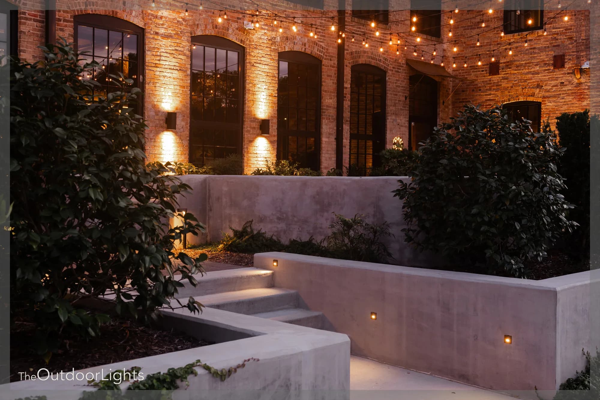 Illuminated brick courtyard and planted steps at Athens Rivet House Hotel